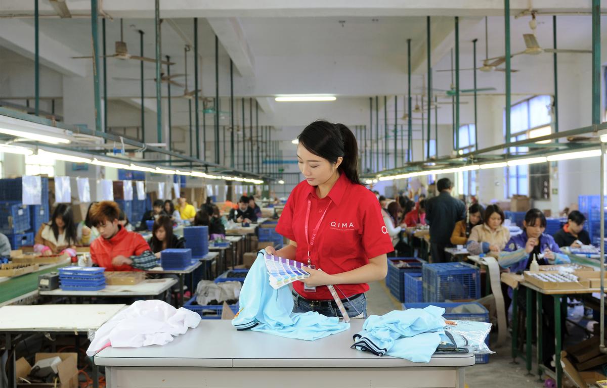Garment quality control inspector checking color of shirt | QIMA