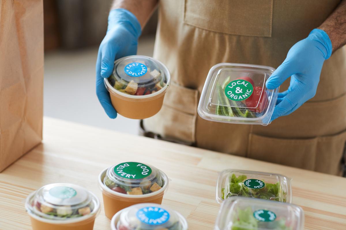 a person holding a containers of food